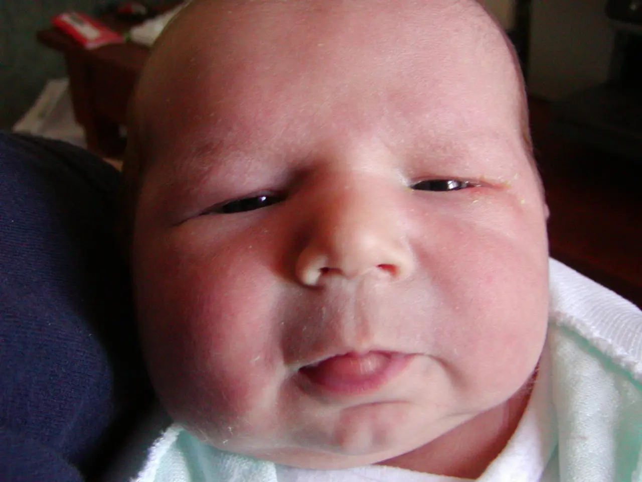 In this image in the foreground there is one baby, and in the background there are some objects.