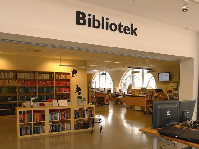 In this picture there are several wooden shelves containing books and there are monitors to the...