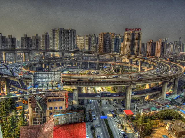 In this image we can see the view of the city. In the middle there is a ring road on which there...