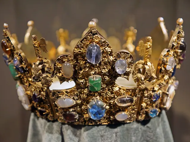 In the picture we can see a crown with some pearls, diamonds, stones in it and it is gold in color...